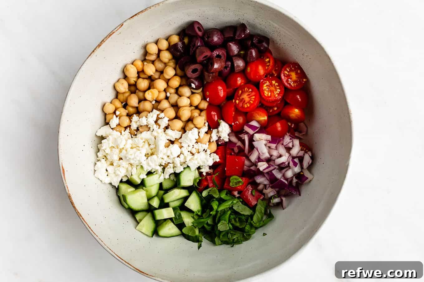 Vibrant Mediterranean Chickpea Salad 8 A bowl of fresh vegetables, chickpeas and feta cheese, ready for the dressing