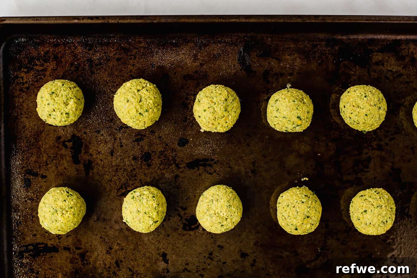 Crispy Oven-Baked Vegan Falafel 12 unbaked falafel on a baking sheet