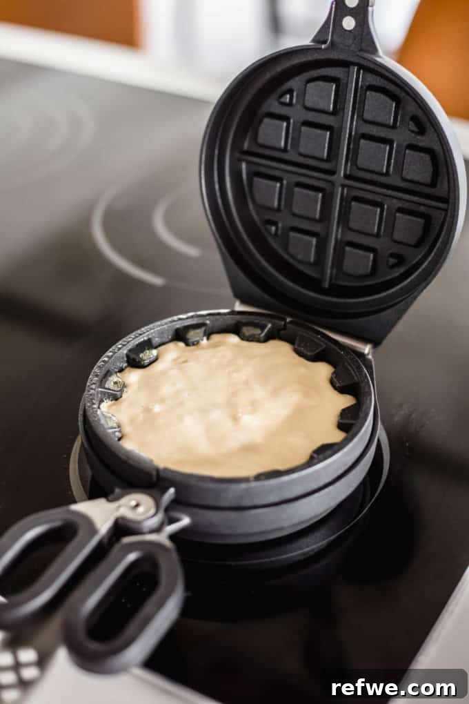 Snickers Banana Bliss Waffles 6 A Wonderffle waffle iron with the filling fully covered by an additional layer of waffle batter, ready to be closed and cooked.