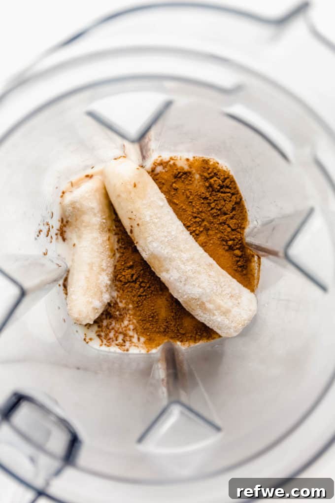 Liquid Banana Bread 4 Ingredients like bananas, almond milk, and cinnamon being added to a blender for the smoothie.