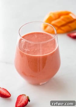 a strawberry mango smoothie with strawberries on the side