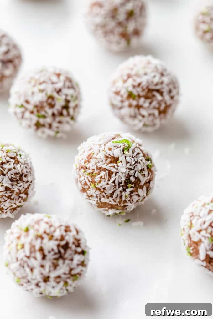 Key Lime Power Bites 2 A key lime pie energy ball with shredded coconut and lime zest on it, highlighting its fresh appeal.