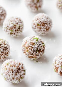 A key lime pie energy ball with shredded coconut and lime zest on it