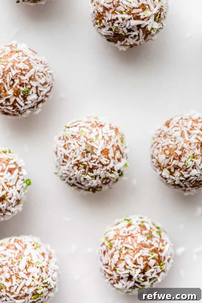 Key Lime Power Bites 4 Key Lime energy balls arranged artfully on a sleek marble board, suggesting elegance and freshness.