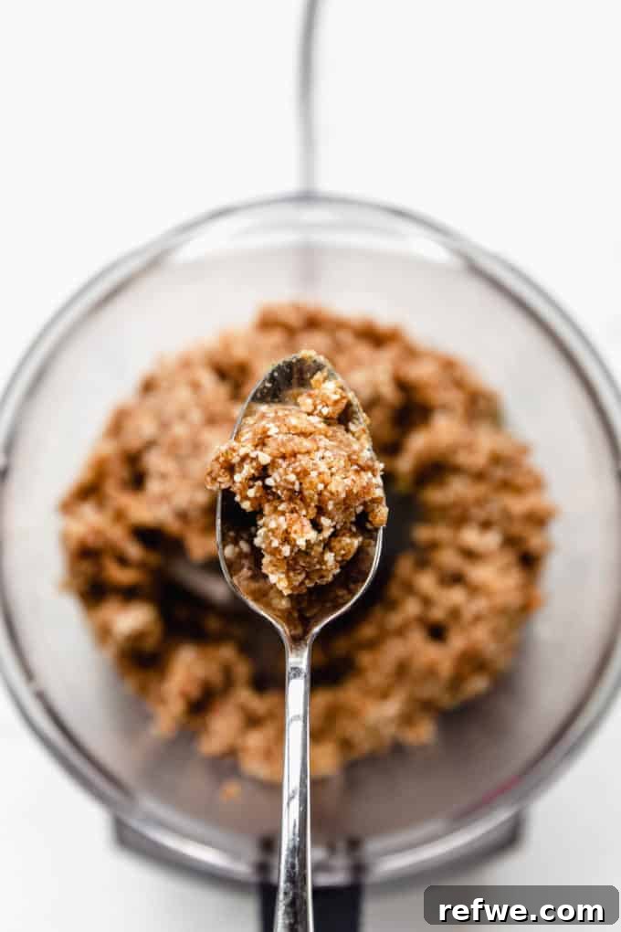 Key Lime Power Bites 7 A spoon holding a portion of the key lime energy ball mixture, poised for rolling.