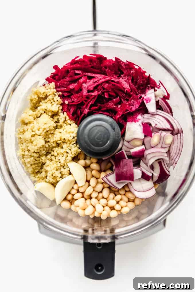 Vibrant Vegan Beet Burgers 3 Raw beets, cooked quinoa, onion, garlic, and white beans are placed in a food processor, ready for blending.