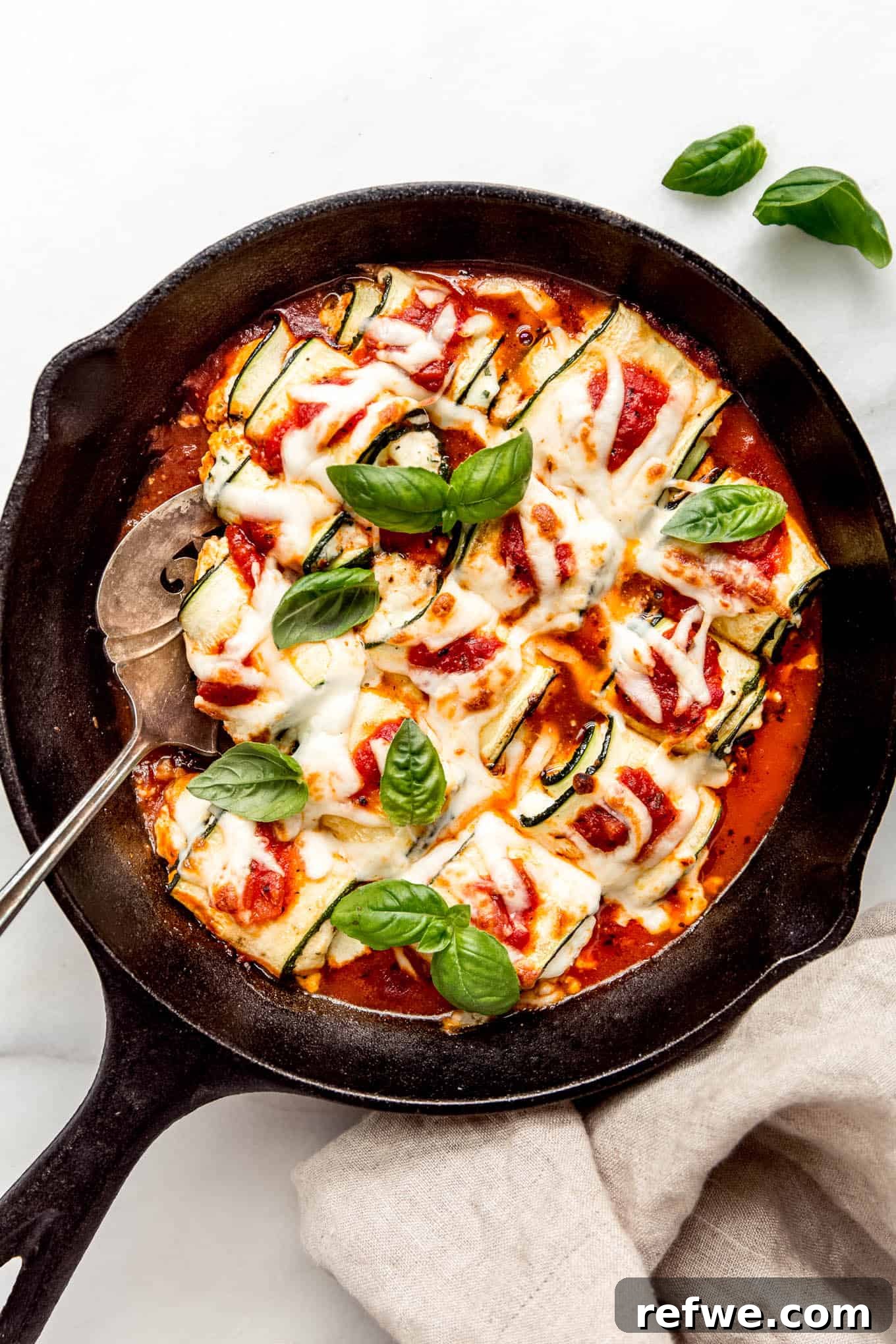 Creamy Ricotta Zucchini Pinwheels 2 Zucchini involtini in a cast iron skillet topped with fresh herbs