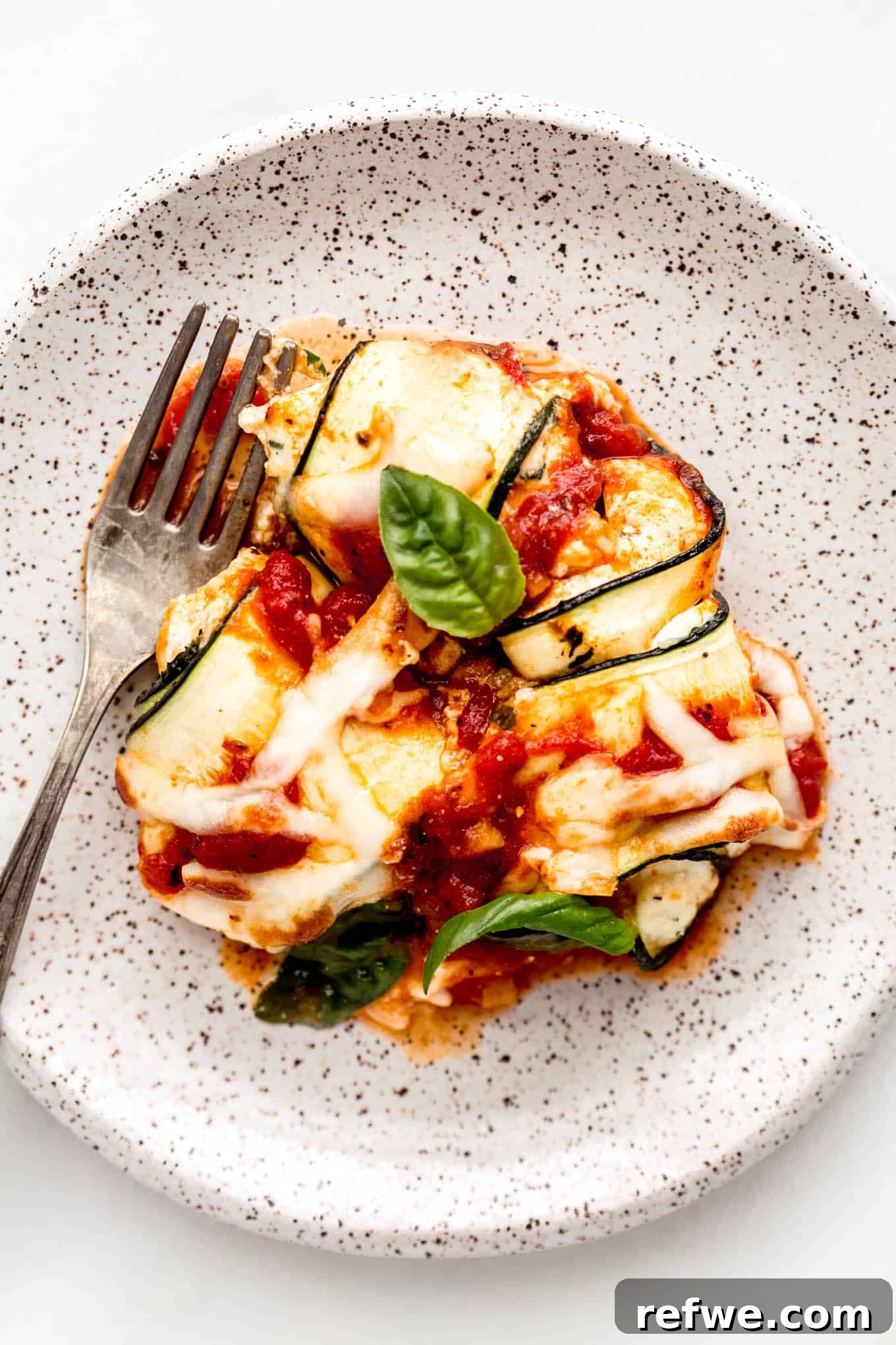 Creamy Ricotta Zucchini Pinwheels 12 Zucchini involtini on a white speckled plate