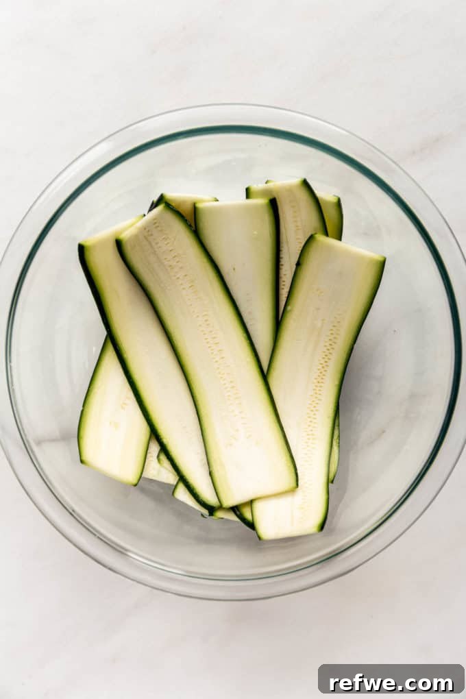 Creamy Ricotta Zucchini Pinwheels 3 Slices of zucchini in a clear mixing bowl