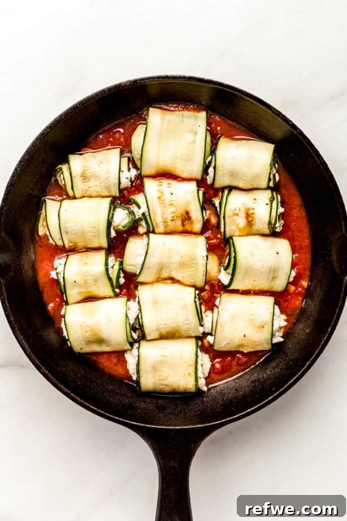 Creamy Ricotta Zucchini Pinwheels 9 zucchini roll ups on tomato sauce in a cast iron skillet