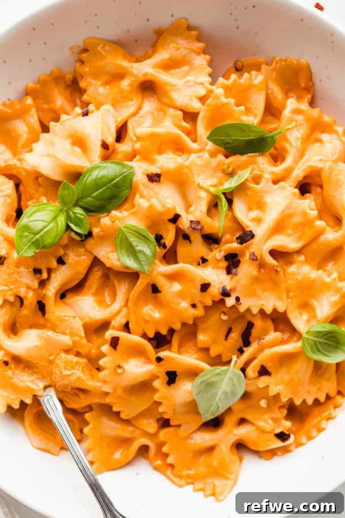 Velvety Vegan Vodka Pasta 14 A vibrant bowl of farfalle pasta generously coated in rich, creamy vegan vodka sauce, ready to be enjoyed.