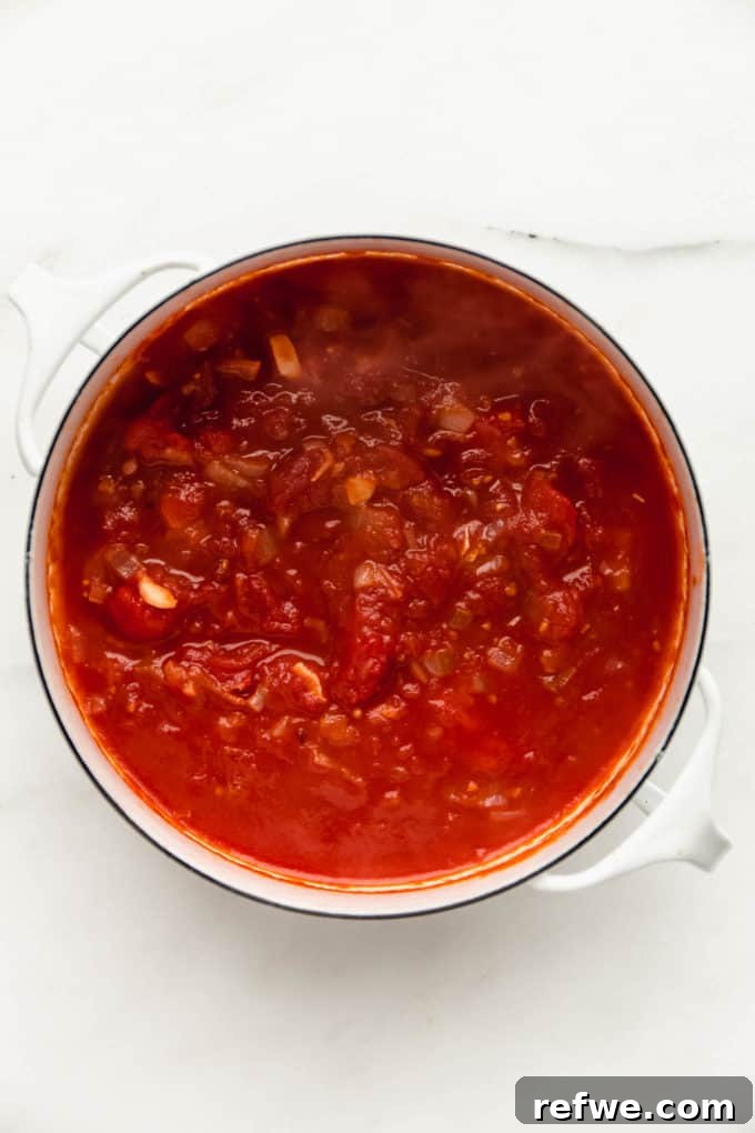 Velvety Vegan Vodka Pasta 6 A white pot with rich, red tomato sauce simmering gently, indicating flavor development.