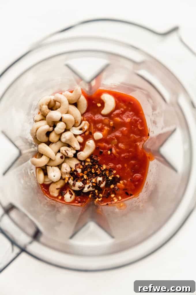 Velvety Vegan Vodka Pasta 7 A blender filled with the simmering tomato sauce, raw cashews, and chili flakes, ready to be blended into a creamy concoction.