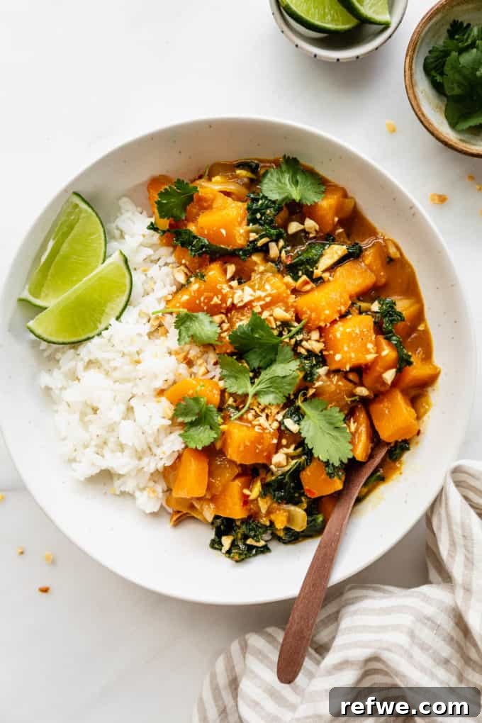 Velvet Squash Curry 10 A bowl of butternut squash curry and rice, garnished with cilantro, with a napkin on the side