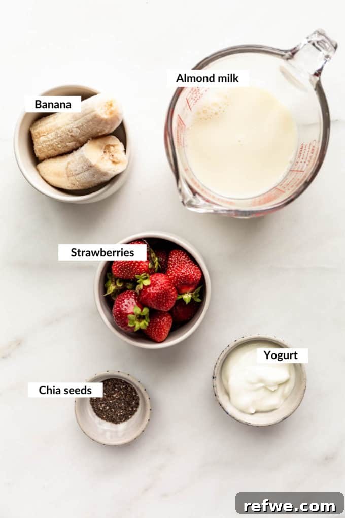 Nutrient-Rich Strawberry Banana Chia Seed Smoothie 3 A vibrant flat lay showcasing the simple, wholesome ingredients for a strawberry chia seed smoothie: fresh strawberries, a ripe banana, chia seeds, creamy yogurt, and almond milk.