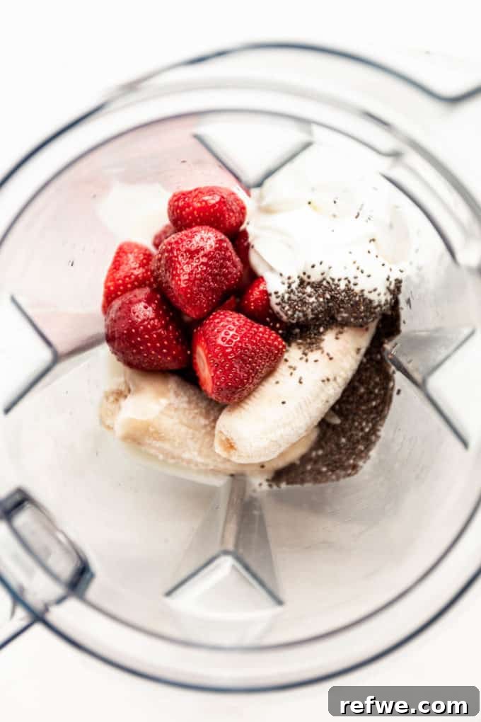 Nutrient-Rich Strawberry Banana Chia Seed Smoothie 4 The initial ingredients—strawberries, yogurt, chia seeds, and bananas—carefully layered in a blender container, ready for blending.