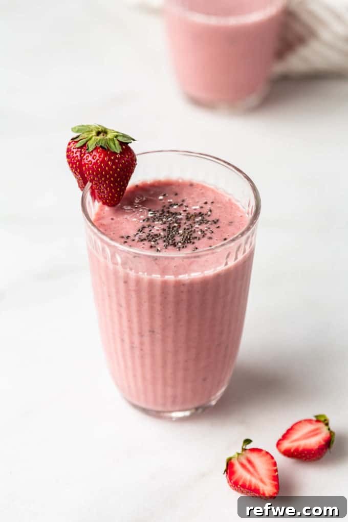 Nutrient-Rich Strawberry Banana Chia Seed Smoothie 7 A beautifully presented chia seed smoothie in a glass, topped with a sprinkle of chia seeds and a fresh strawberry, ready to be enjoyed.