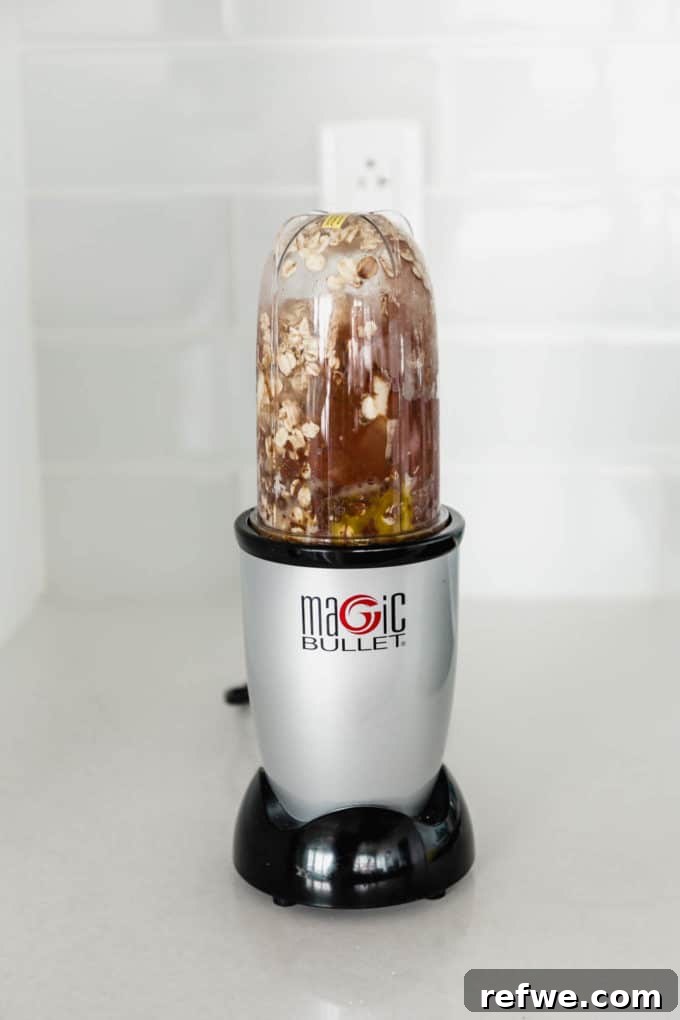 Morning Chocolate Indulgence 4 A magic bullet blender filled with oats, banana, cocoa powder, and almond milk before blending.