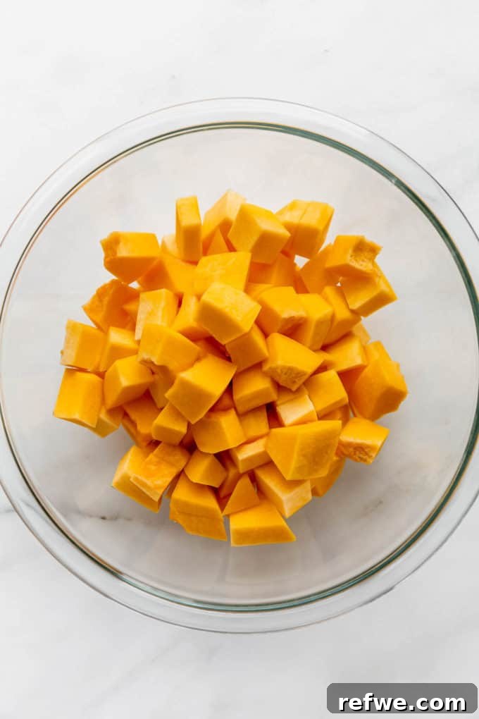 Autumn Roasted Pumpkin Salad 4 Cubed pumpkin pieces resting in a clear mixing bowl, ready for seasoning.