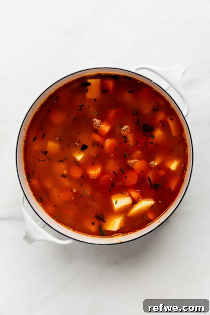Nourishing Plant-Based Lentil Stew 7 Uncooked lentil stew in a white pot, covered and simmering