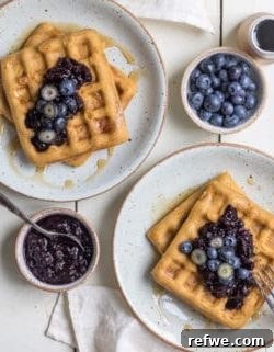 Beautifully plated cornbread waffles with fresh blueberry compote and garnish