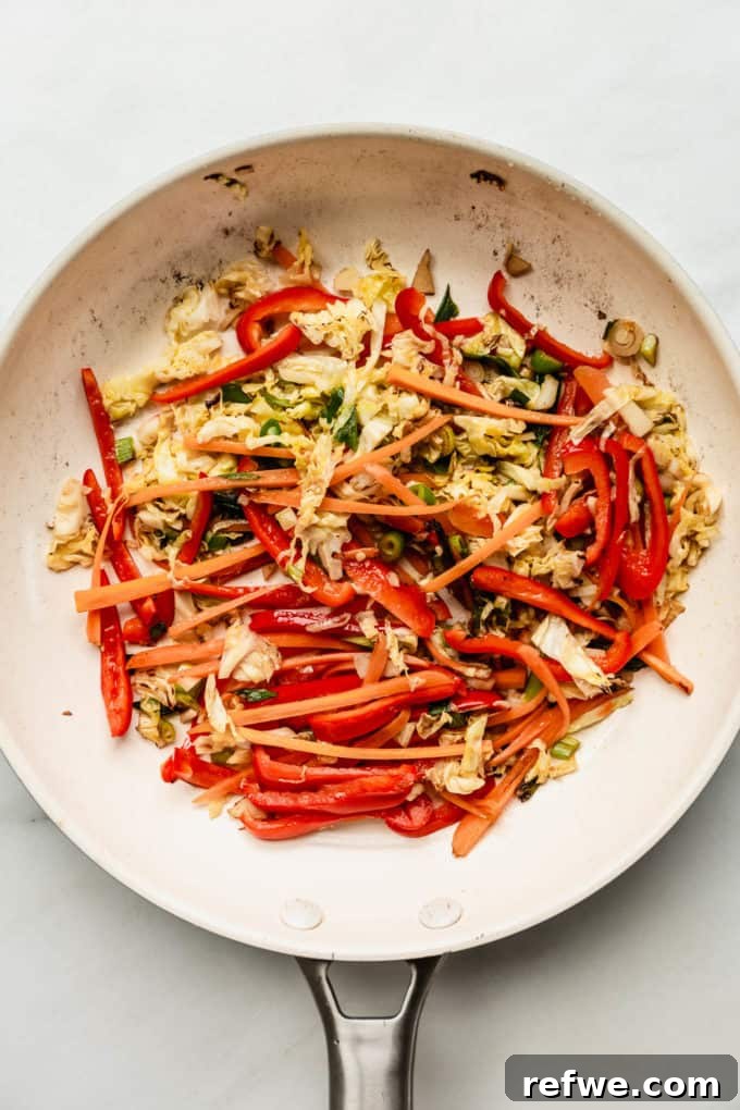Plant-Based Vegetable Noodle Stir-Fry 5 A white pan showcasing stir-fried vegetables, perfectly tender and aromatic, ready for the noodles.