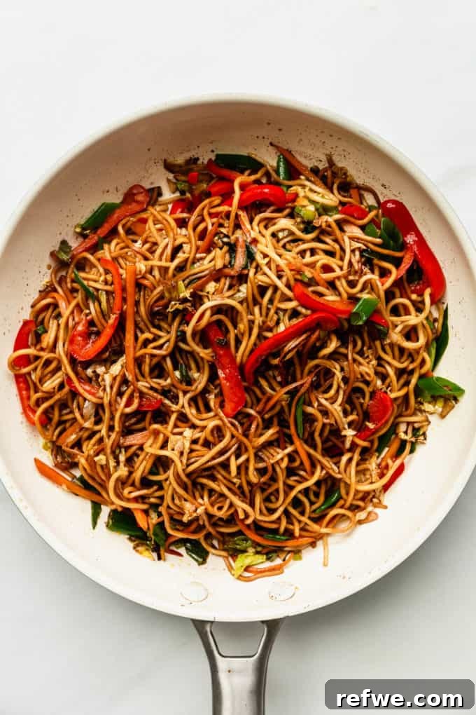 Plant-Based Vegetable Noodle Stir-Fry 9 The finished vegan chow mein, vibrant and steaming, presented beautifully in a white pan, ready to be served.