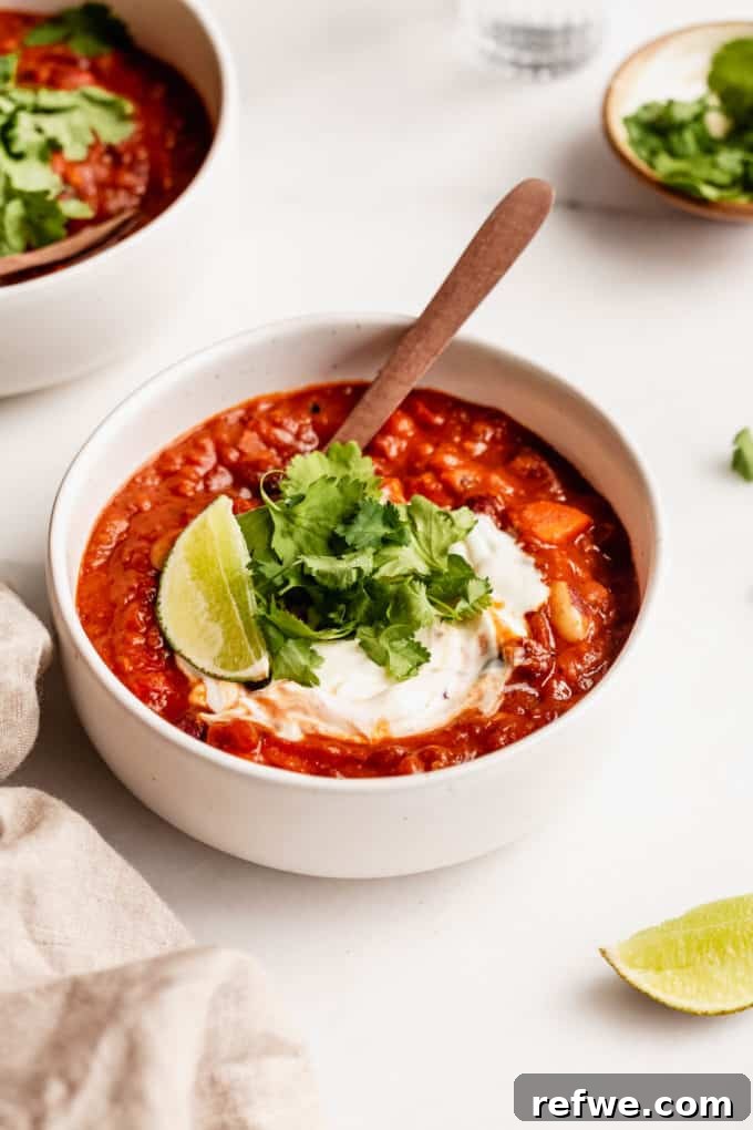 Irresistible Vegan Chili 12 A bowl of white chili on a table with lime and a napkin on the side