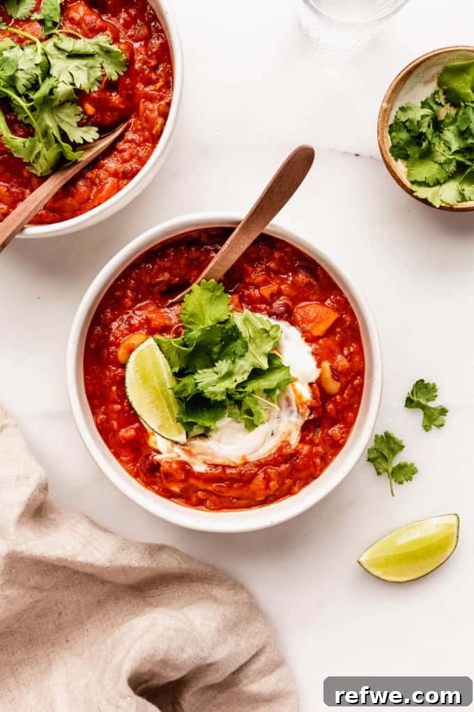 Irresistible Vegan Chili 10 two bowls of vegan chili topped with cilantro with spoons in them