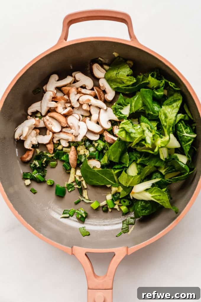 Fast and Simple Yaki Udon Stir Fry 5 Fresh baby bok choy and sliced shiitake mushrooms added to the pan with sautéed aromatics, ready for stir-frying and becoming tender-crisp.