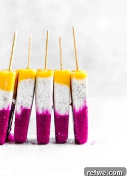 Five tropical coconut chia popsicles stacked next to each other, highlighting their beautiful layered colors.