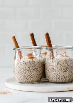 three jars filled with eggnog chia pudding topped with yogurt and spices