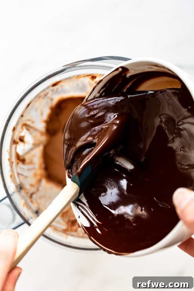 Velvet Mint Chocolate Pudding 7 Melted dark chocolate being elegantly poured into the blender, mixing with the existing chocolate pudding base to enhance its richness.