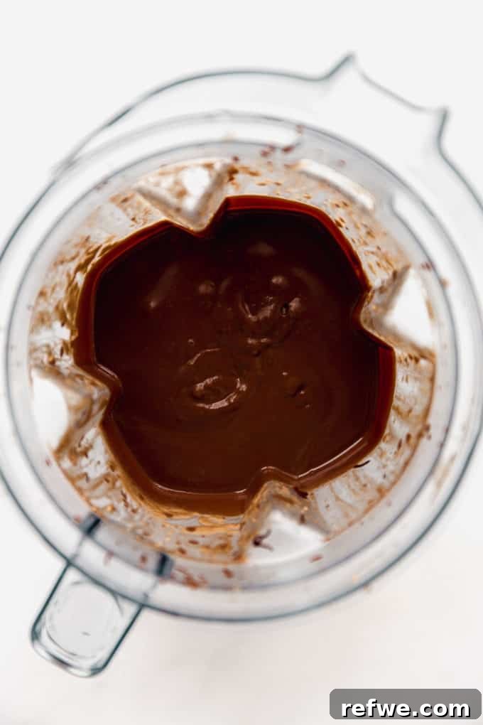 Velvet Mint Chocolate Pudding 9 The finished mint chocolate pudding mixture swirling in the blender, showcasing its smooth and thick consistency before being poured into jars.