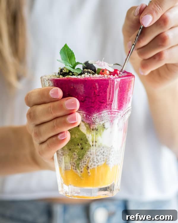 Close-up of vibrant layered chia pudding with kiwi, raspberry, and mango puree