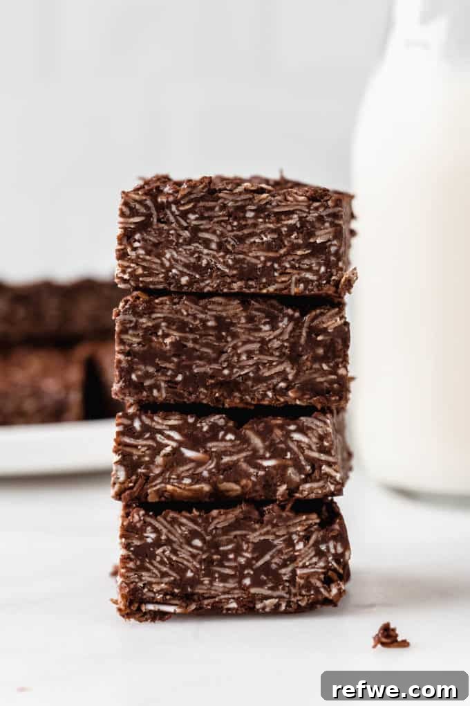 Chocolate Coconut No Bake Dream Bars 3 A stack of four tempting chocolate coconut bars, ready to be enjoyed as a healthy snack.