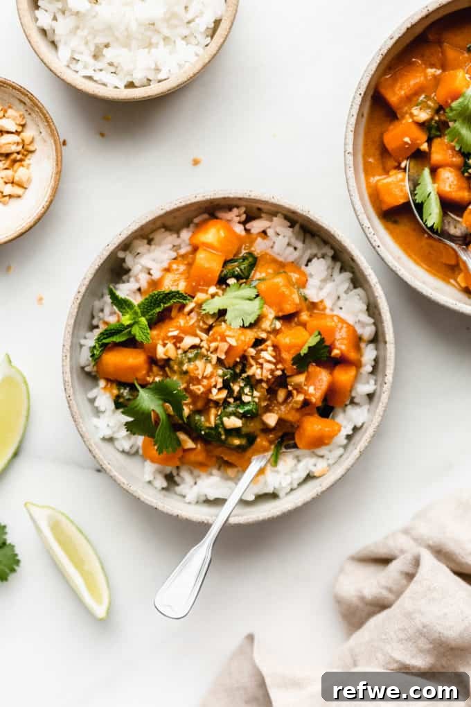 Two beautifully plated bowls of sweet potato curry over rice, adorned with fresh lime wedges and crushed peanuts, ready to be enjoyed