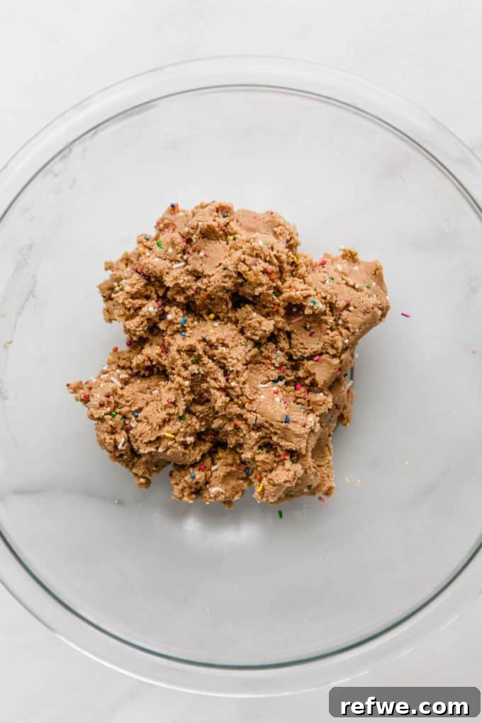 Funfetti Protein Bites 9 Smooth, colorful birthday cake protein ball dough, perfectly blended and ready to be rolled, contained in a mixing bowl.
