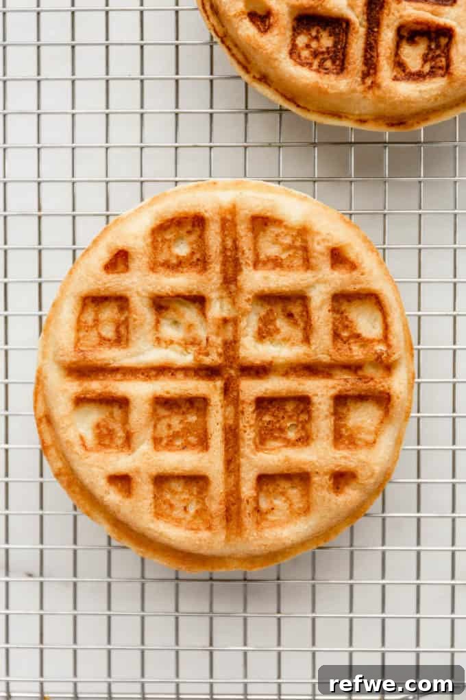 Fluffy Almond Flour Waffles 10 A single almond flour waffle, perfectly cooked to a golden crisp, cooling on a wire rack.