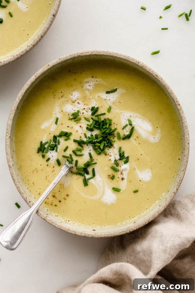 Velvety Vegan Broccoli Bliss 2 Blended creamy vegan broccoli soup in a ceramic bowl, garnished with fresh herbs.