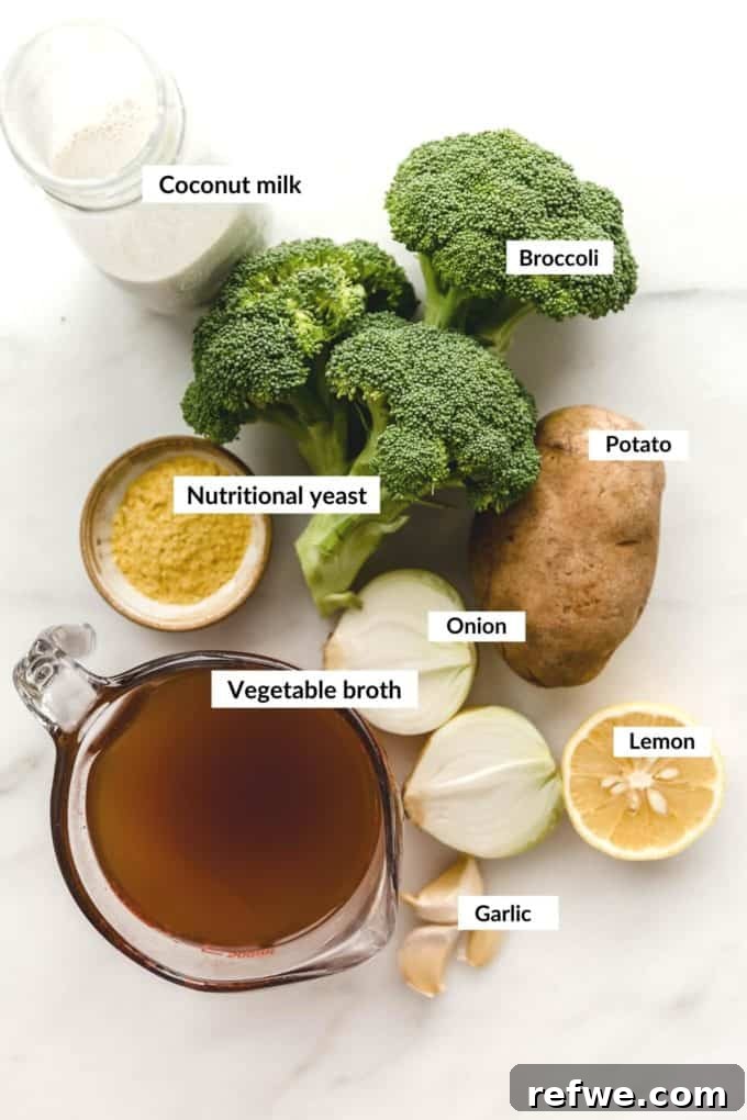 Velvety Vegan Broccoli Bliss 3 Fresh ingredients laid out for vegan broccoli soup including broccoli florets, onion, garlic, potato, and a can of coconut milk.