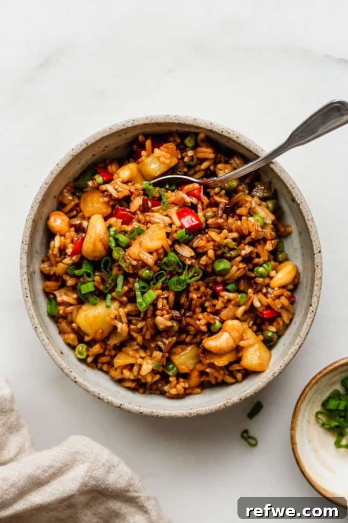 Pineapple Paradise Fried Rice 16 A beautifully presented bowl of Thai pineapple fried rice with a spoon, ready to be enjoyed.