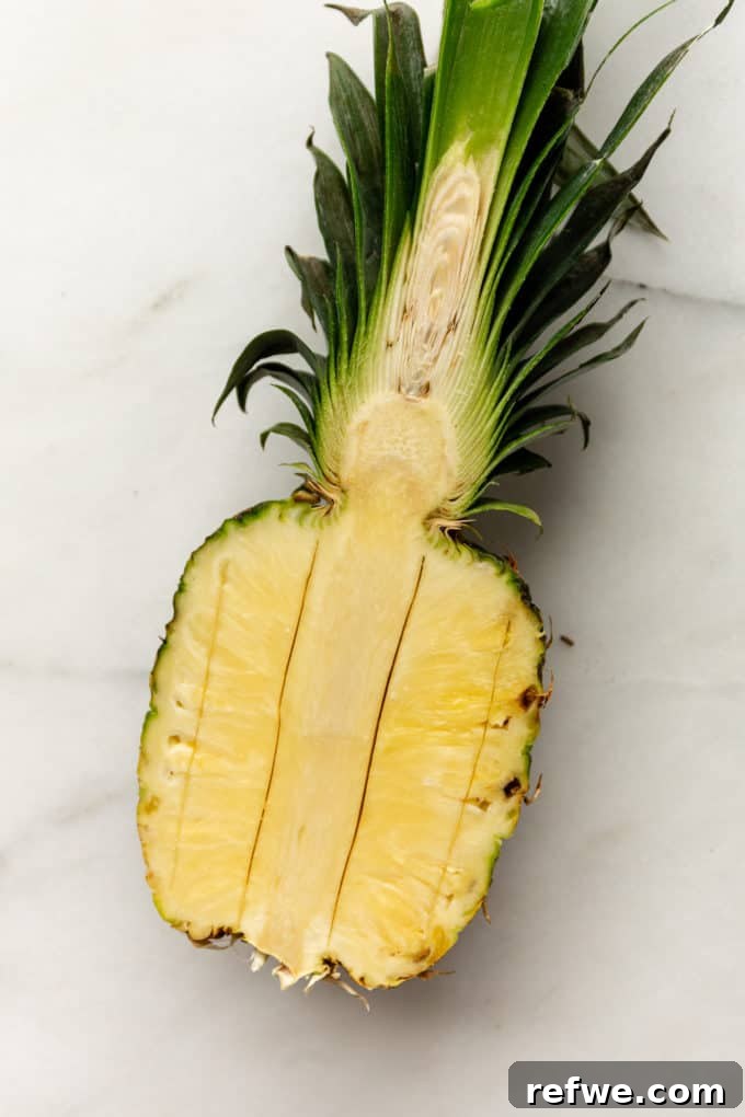 Pineapple Paradise Fried Rice 5 A pineapple half with deep vertical cuts made along the sides of the core, illustrating the next step in preparing the bowl.
