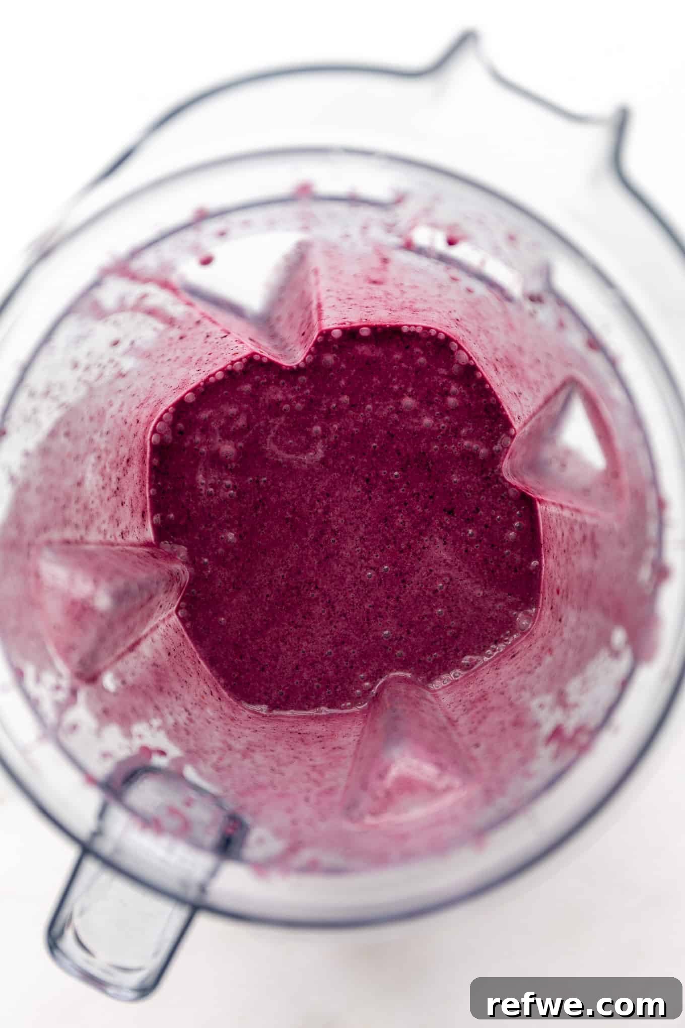 Vibrant Berry Spinach Blend 5 A blueberry spinach smoothie in a blender, mid-blend, showing the swirling purple color.