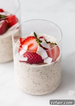 A cup of protein overnight oats topped with fresh strawberries, ready for serving.