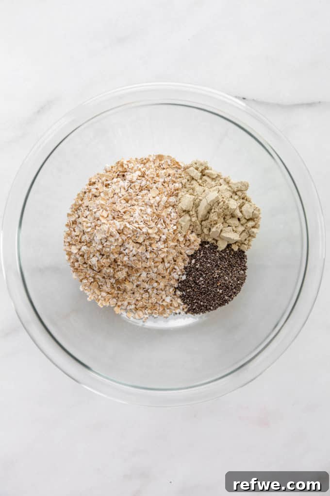 Power Protein Overnight Oats 4 Oats, protein powder, and chia seeds combined in a mixing bowl.