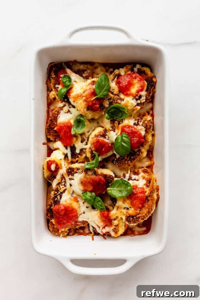 Golden Cauliflower Parmesan Bake 7 A white baking dish filled with freshly baked Cauliflower Parmesan, cheese bubbling