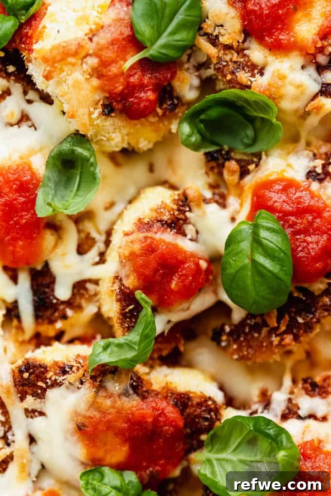 Golden Cauliflower Parmesan Bake 8 Close-up of Cauliflower Parmesan topped with melted cheese, tomato sauce, and fresh basil leaves