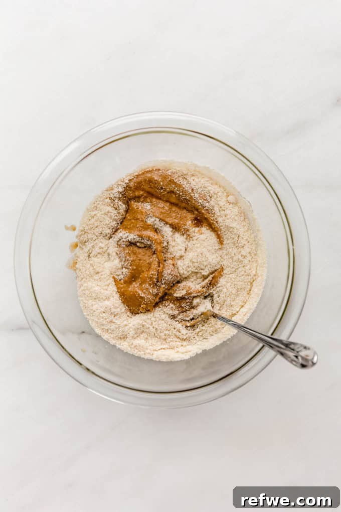 Irresistible Vegan Peanut Butter Treats 3 Almond flour and creamy peanut butter in a clear mixing bowl, ready to be combined.