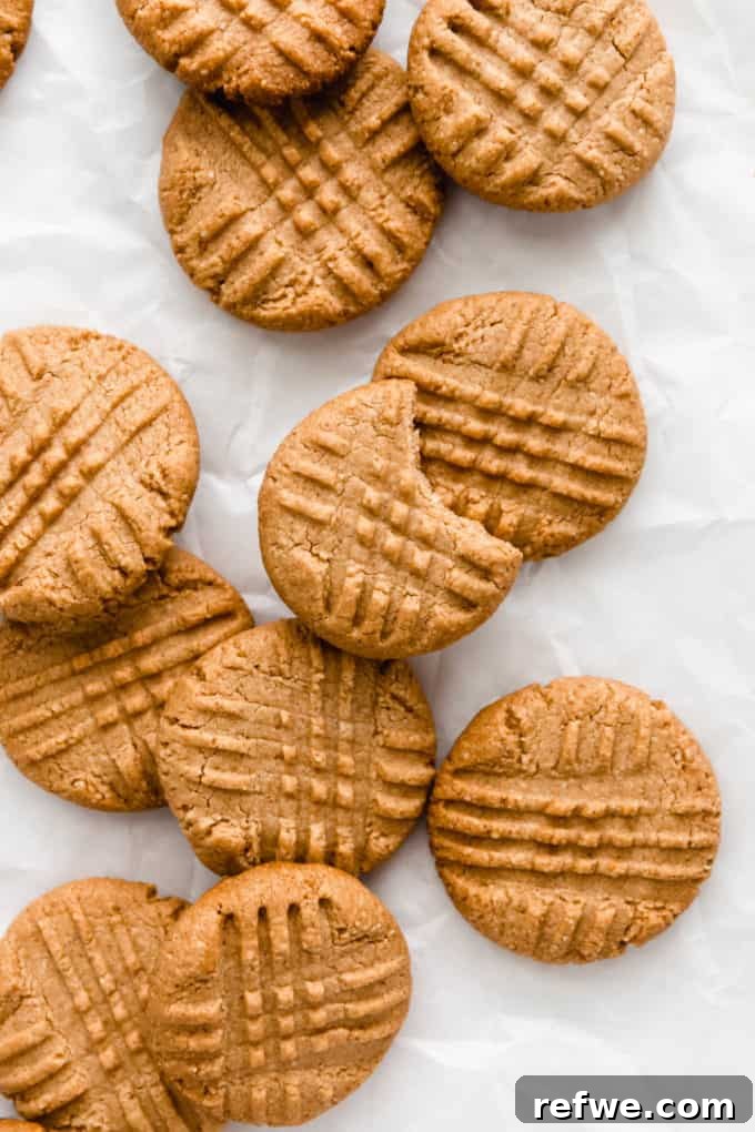 Irresistible Vegan Peanut Butter Treats 8 A batch of baked vegan peanut butter cookies resting on parchment paper, ready to be enjoyed.